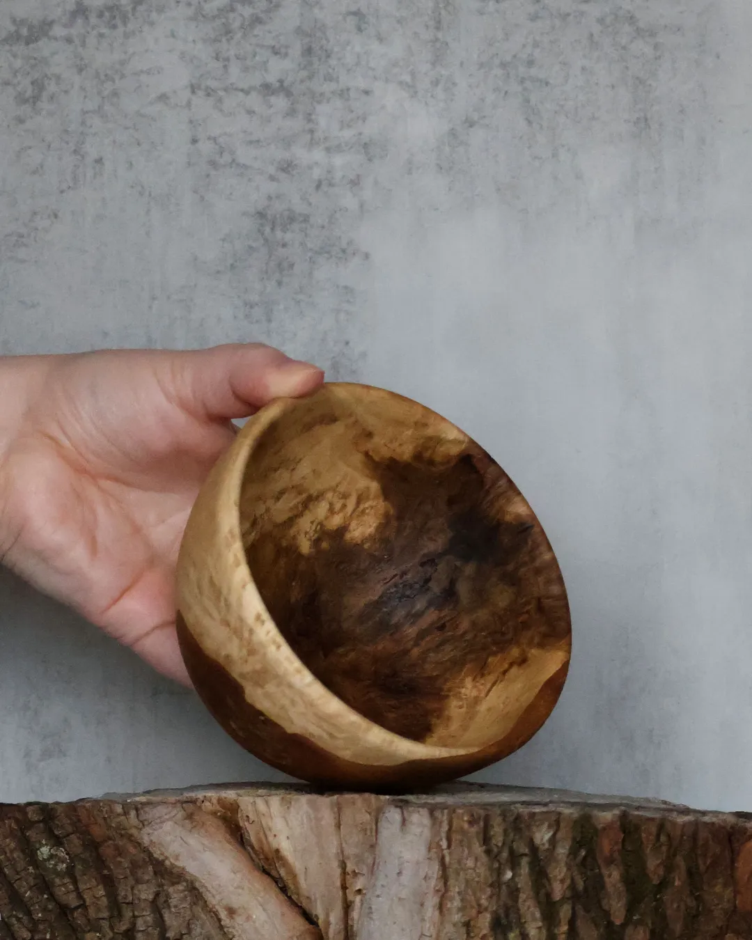 Small hand-turned burl bowl tilted to reveal spalted interior grain