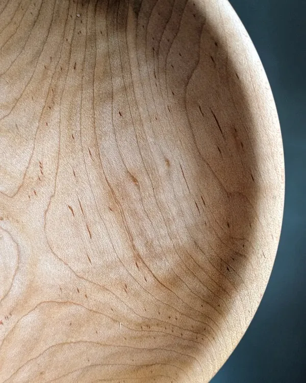 Close-up of hand-turned maple bowl interior showing fine wood grain detail