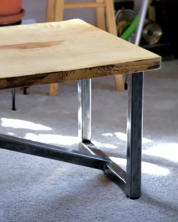Steel trapezoid table leg detail on live-edge maple waterfall table
