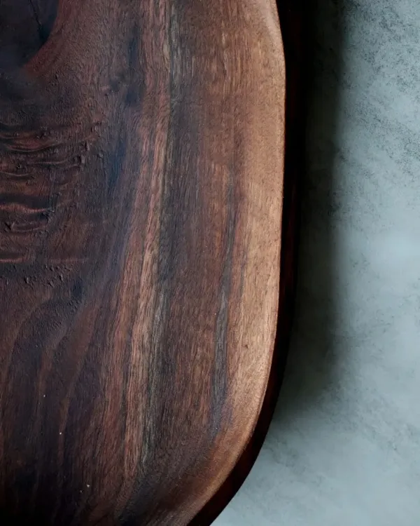 Detail of hand-turned walnut bowl with natural live edge rim