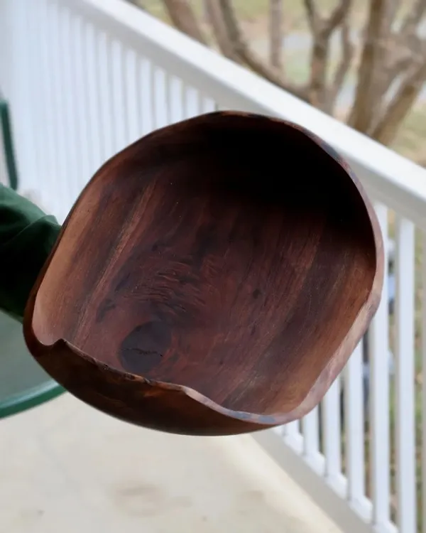 Natural-edge walnut bowl with live bark rim held outdoors