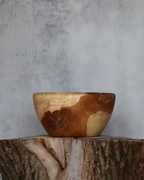 Large hand-turned walnut platter with natural live edge held for scale