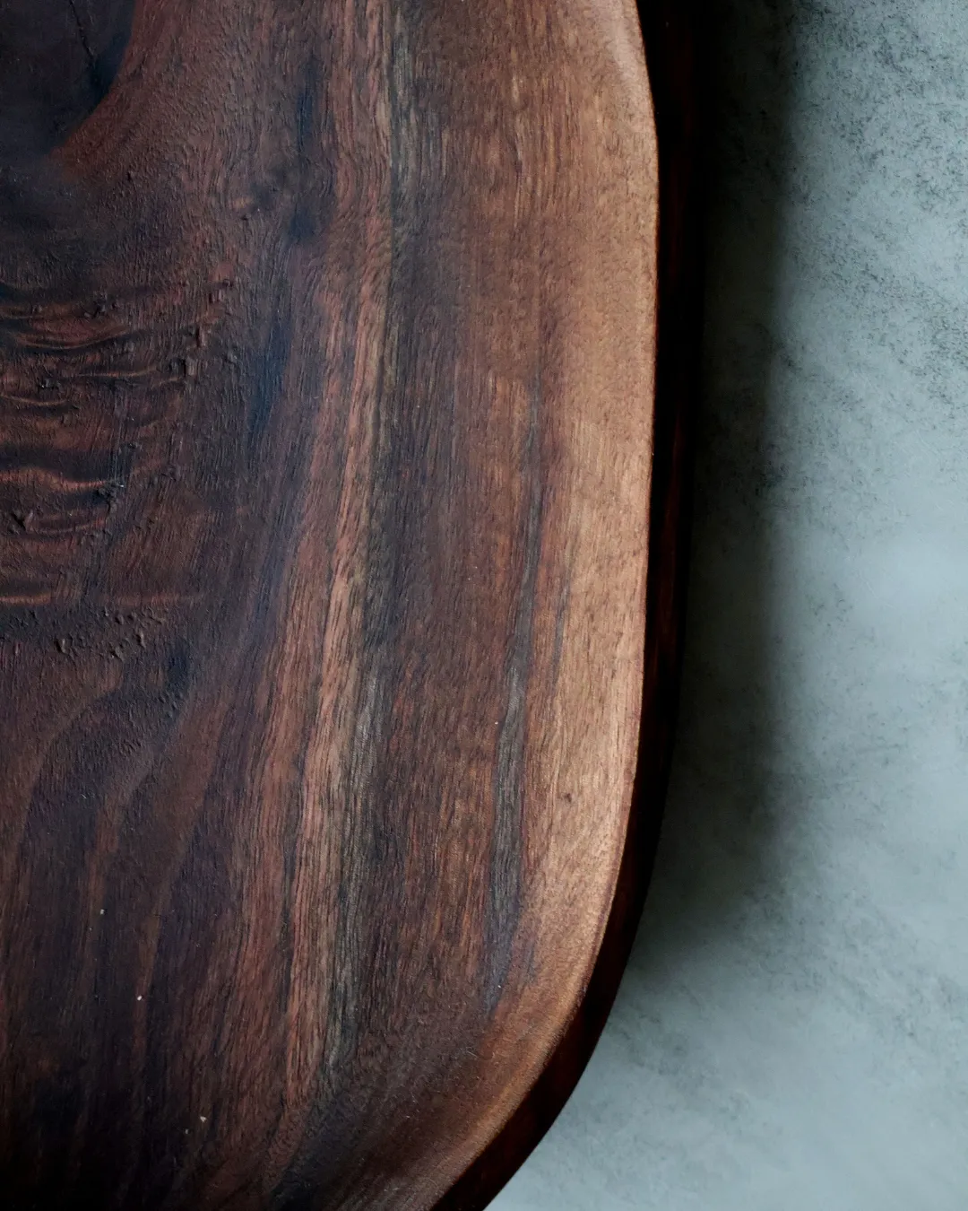 Detail of hand-turned walnut bowl with natural live edge rim